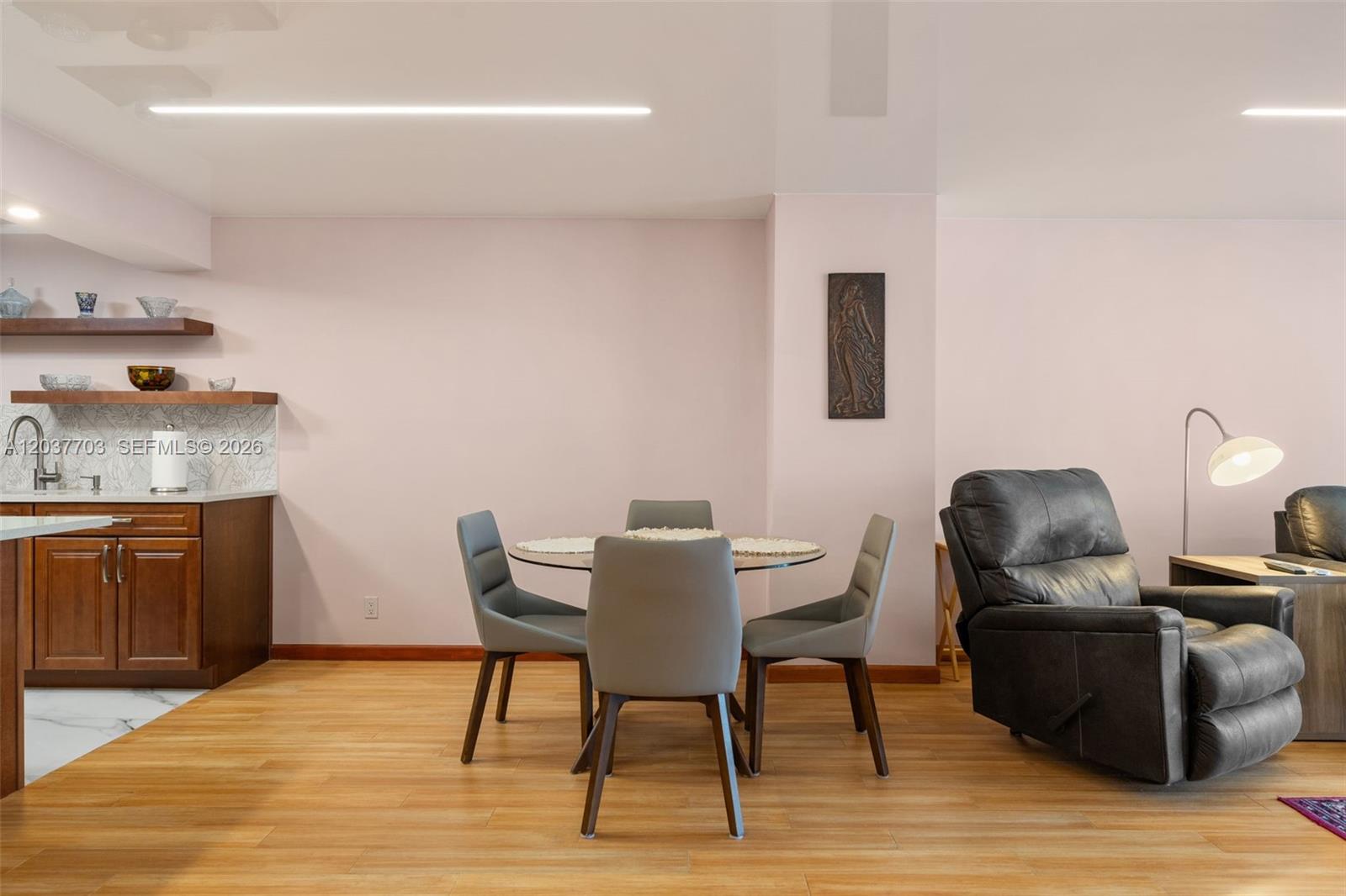 A dining area with a glass table and four chairs sits next to a kitchen counter — 1865 S Ocean Dr # 16B, Hallandale Beach FL 33009, HALLANDALE BEACH, FL