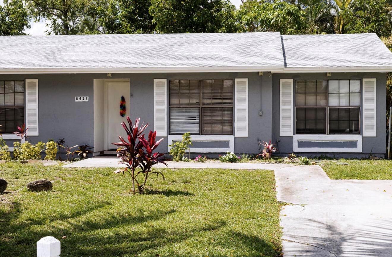 A single-story gray house with white shutters, a front door, and a landscaped front yard — 5437 Greenwood Drive, Delray Beach FL 33484, DELRAY BEACH, FL