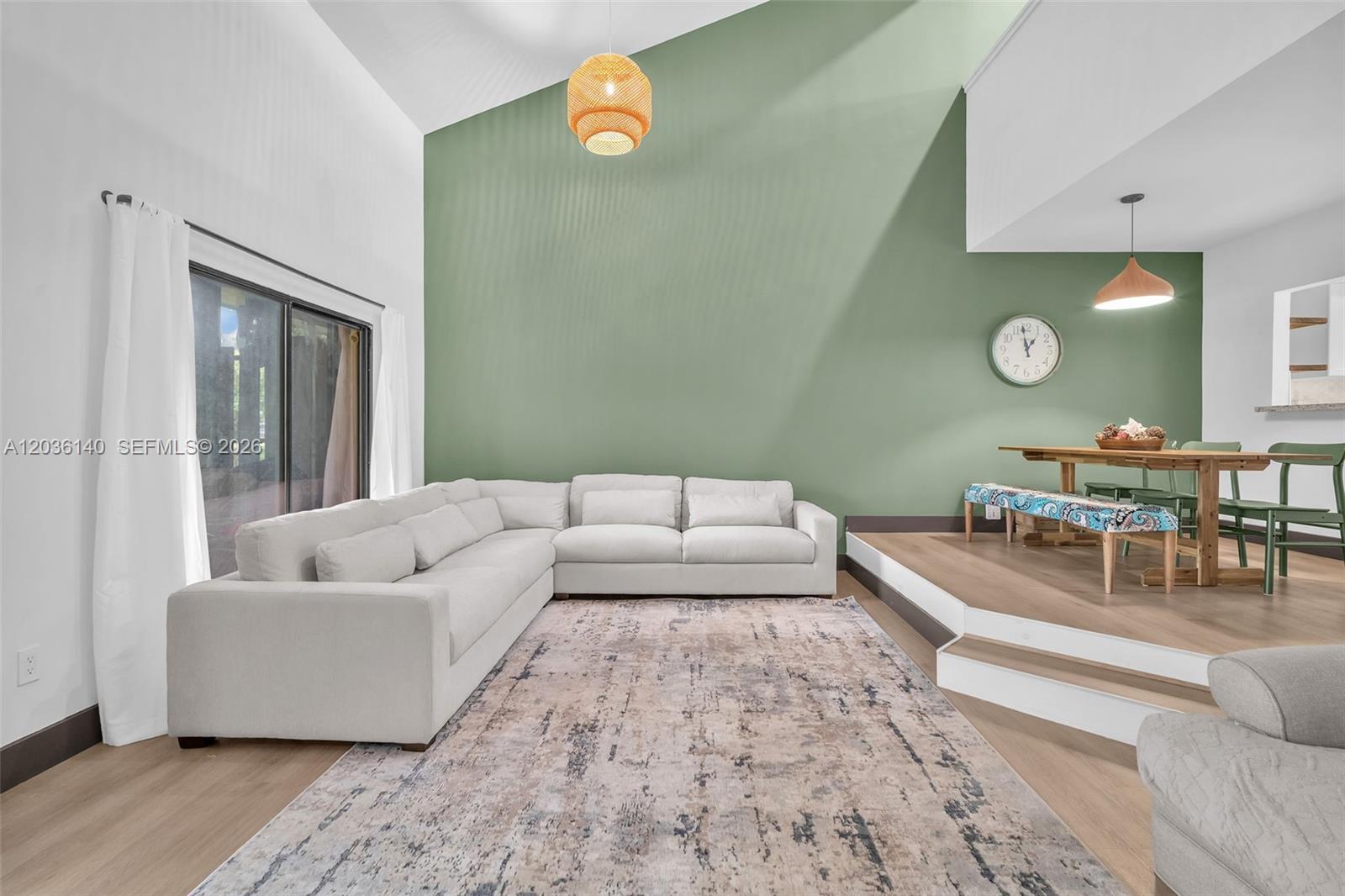 A living and dining area features a vaulted ceiling, sage green accent wall, and sectional sofa — 4171 SW 85th Ave, Davie FL 33328, DAVIE, FL