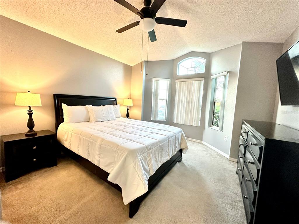 A bedroom features a bed with a black frame, two nightstands, and a dresser — 307 FOX LOOP, DAVENPORT, FL