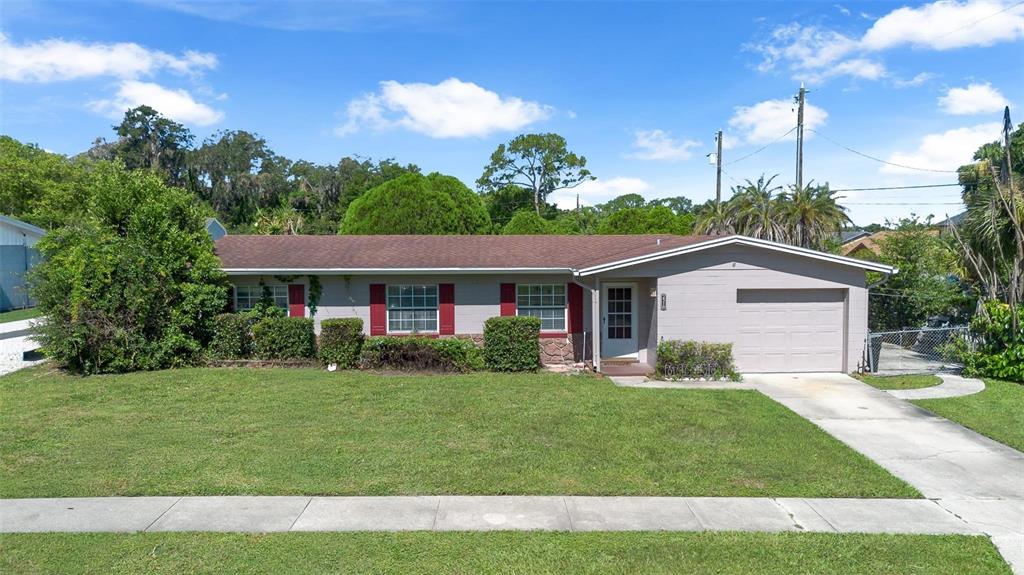 A single-story house with a gray exterior, red shutters, and an attached garage — 2510 DRIFTWOOD DRIVE, FERN PARK, FL