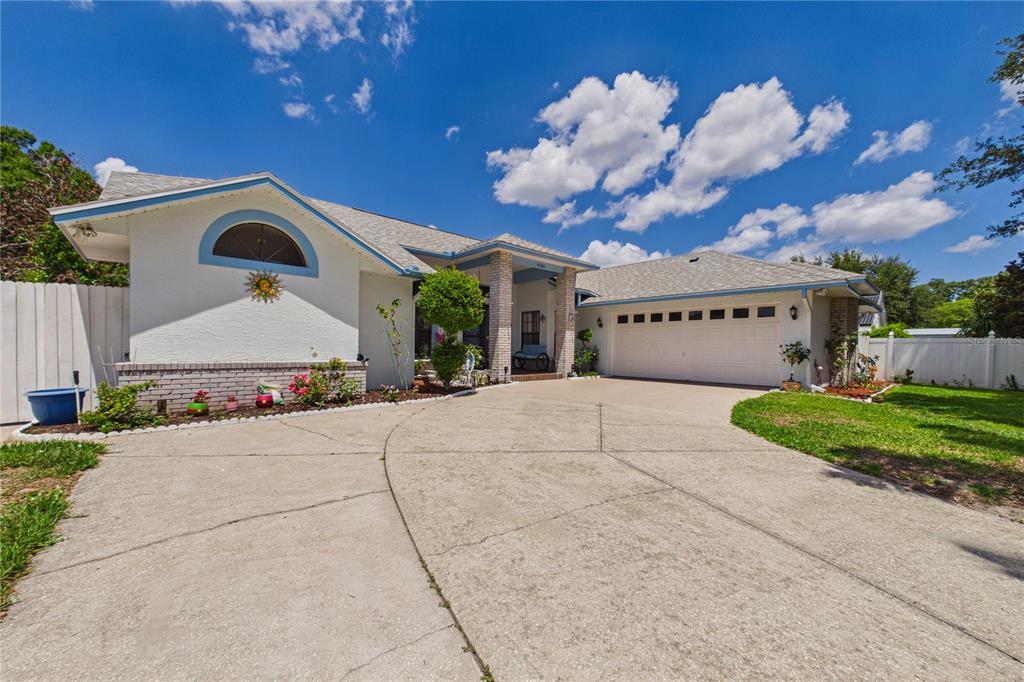 A single-story house with a white stucco exterior, a two-car garage, and a concrete driveway — 4386 WYNDCLIFF CIRCLE, ORLANDO, FL