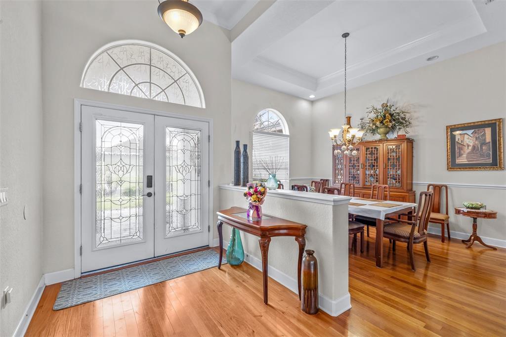 An entryway with hardwood floors leads into a dining room separated by a half wall — 6798 HARTSWORTH DRIVE, LAKELAND, FL