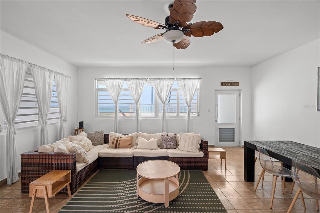 A living room features a wicker sectional, a round coffee table, and ocean views — Luquillo BEACH UNIT A-25, LUQUILLO, PR