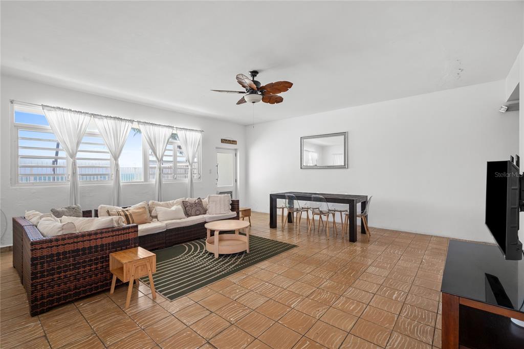 A living and dining area with tiled floors, a sectional sofa, and a dining table — Luquillo BEACH UNIT A-25, LUQUILLO, PR