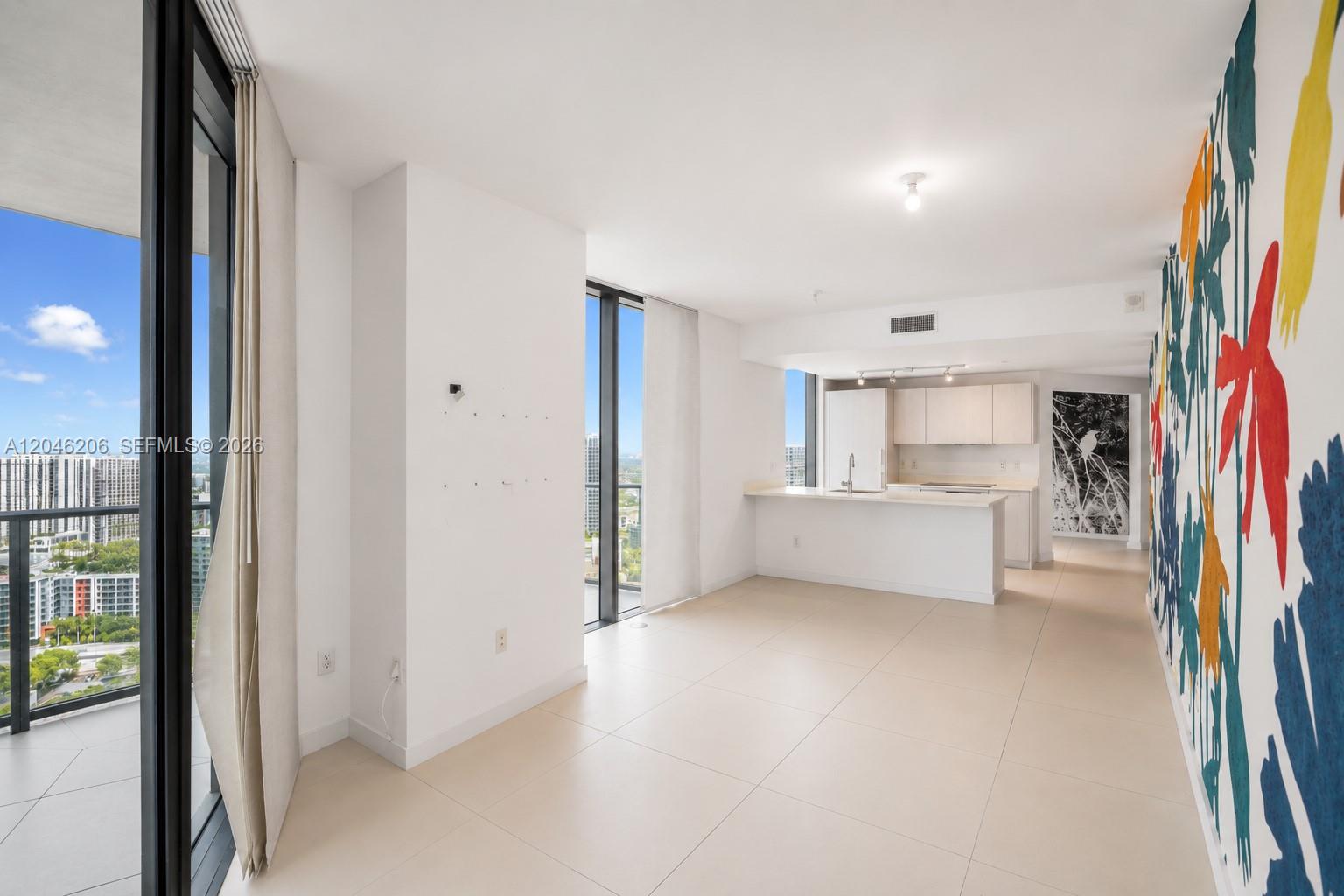 An open-concept living area features tile floors, a kitchen island, and a colorful mural wall — 501 NE 31st St # 3208, Miami FL 33137, MIAMI, FL