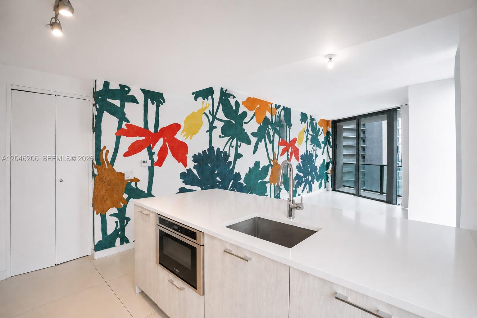 A kitchen island with a sink and microwave sits before a wall with floral wallpaper — 501 NE 31st St # 3208, Miami FL 33137, MIAMI, FL