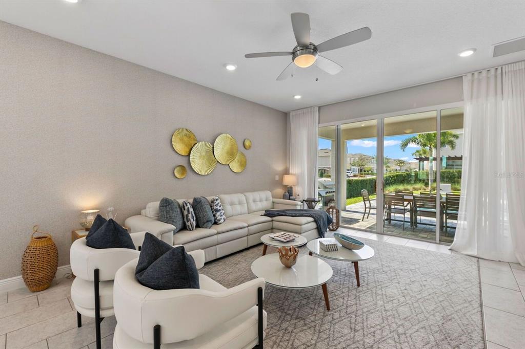 A living room features a white sectional sofa, two armchairs, and sliding glass patio doors — 353 SOUTHFIELD STREET, KISSIMMEE, FL
