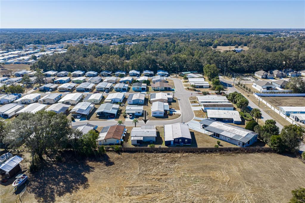 An aerial view shows a residential neighborhood with a marked house and surrounding properties — 35025 MCCULLOUGHS LEAP, ZEPHYRHILLS, FL