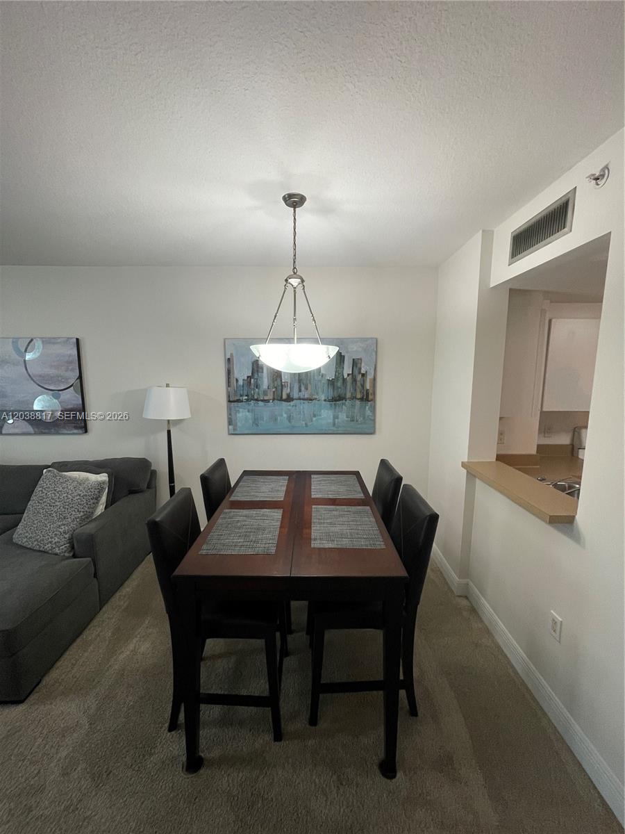 A dining area features a dark wood table with four chairs under a pendant light — 1250 S Miami Ave # 1410, Miami FL 33130, MIAMI, FL