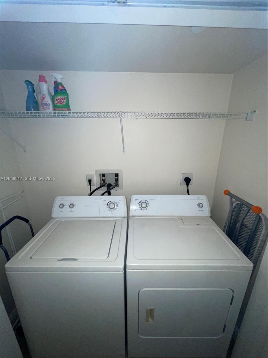 A laundry closet contains a white top-loading washing machine, a dryer, and a wire shelf — 1250 S Miami Ave # 1410, Miami FL 33130, MIAMI, FL
