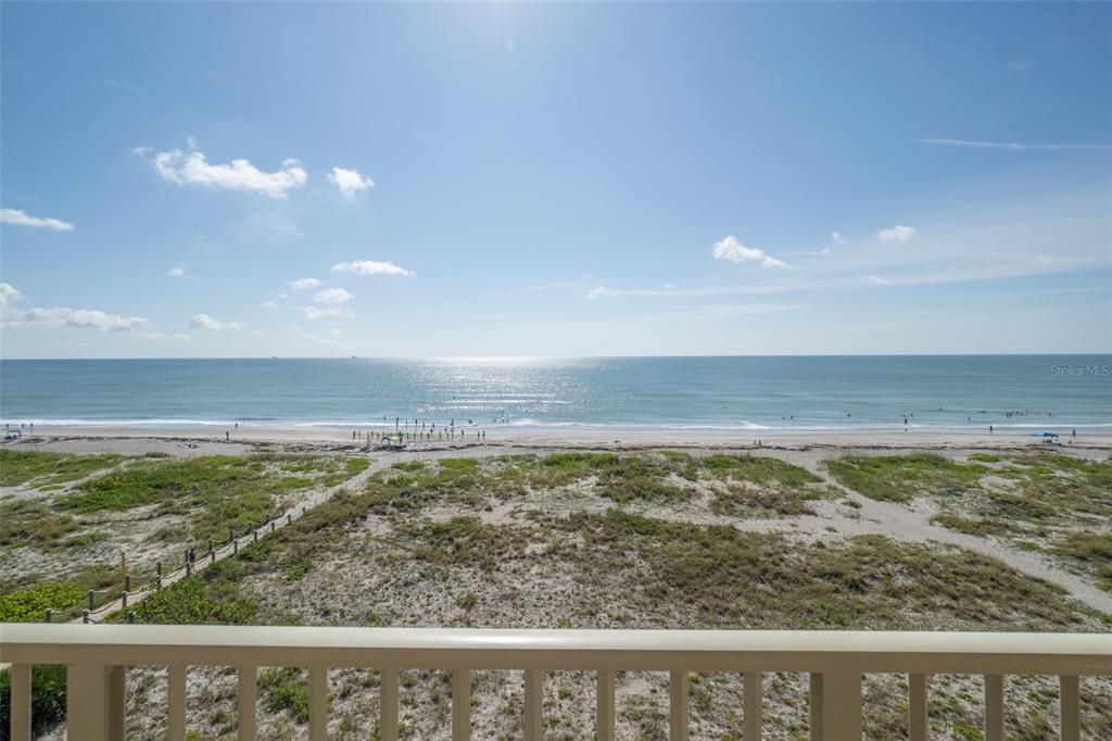 A view of a sandy beach and the ocean from a balcony with railings — 299 N ATLANTIC AVENUE UNIT 602, COCOA BEACH, FL