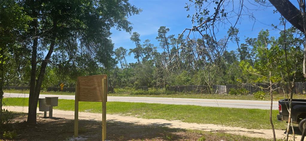 A vacant, grassy lot featuring a wooden sign frame and a road in the background — NE 236TH COURT, FORT MC COY, FL
