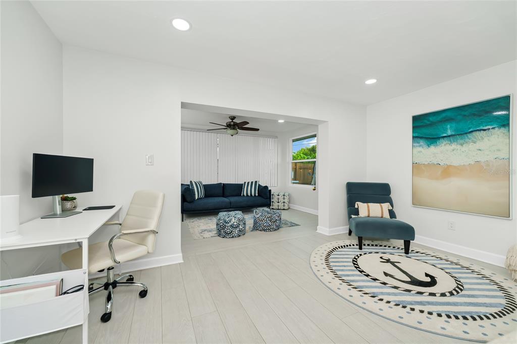 A bright room features a desk, a blue armchair on an anchor rug, and an adjacent living area — 363 HARBOR DR, CAPE CANAVERAL, FL
