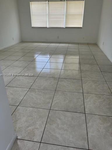 An empty room with light-colored tile flooring and a window with horizontal blinds — 540 SE 2nd Ave # J3, Deerfield Beach FL 33441, DEERFIELD BEACH, FL