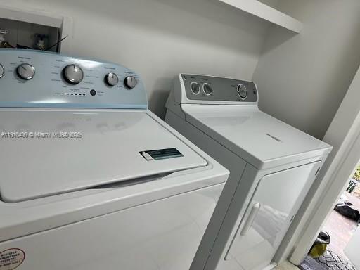A white top-loading washing machine and dryer sit side-by-side in a laundry room — 540 SE 2nd Ave # J3, Deerfield Beach FL 33441, DEERFIELD BEACH, FL