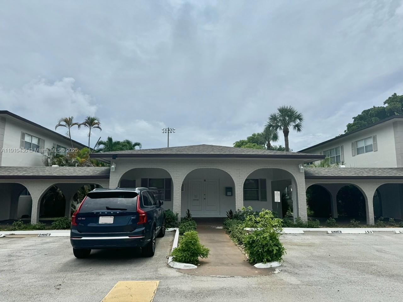 A dark blue SUV is parked in front of a white brick building with arched entryways — 540 SE 2nd Ave # J3, Deerfield Beach FL 33441, DEERFIELD BEACH, FL