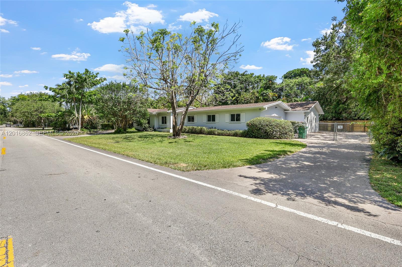 A single-story house with a lawn and driveway sits along a residential street — 7800 SW 132nd St, Pinecrest FL 33156, PINECREST, FL