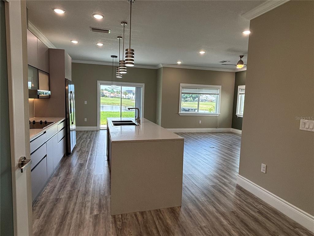 A modern kitchen features a large island, stainless steel appliances, and wood-look flooring — 2049 GREENBRIAR TERRACE, DAVENPORT, FL