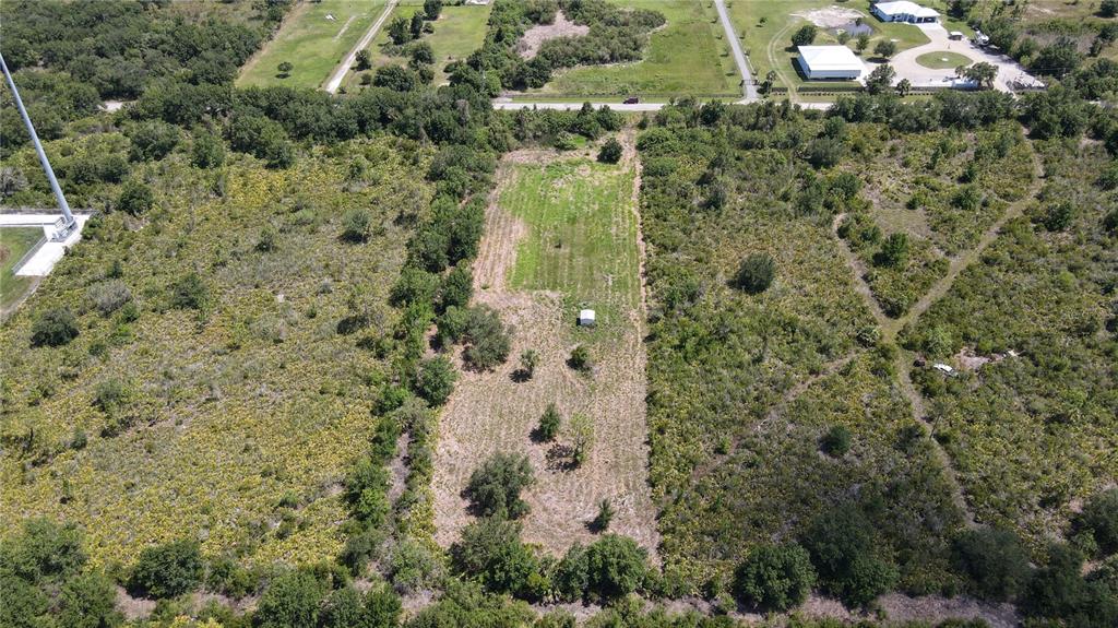 An aerial view shows a rectangular cleared lot surrounded by dense trees and vegetation — 29455 PINE VILLA CIRCLE, PUNTA GORDA, FL