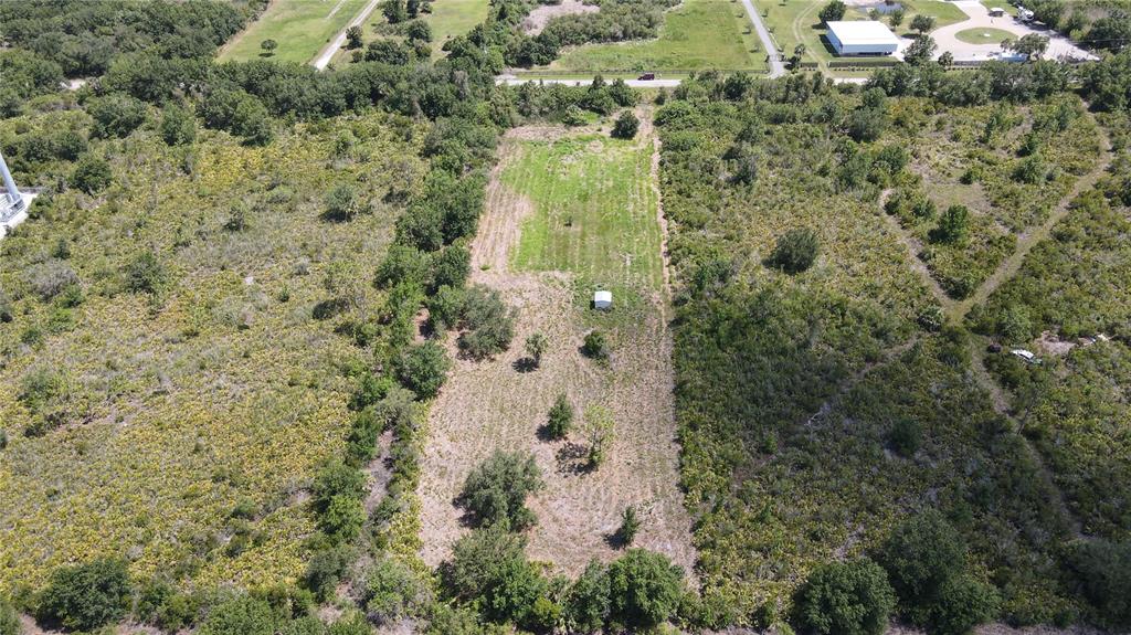 An aerial view shows a rectangular cleared lot with a small shed surrounded by trees — 29455 PINE VILLA CIRCLE, PUNTA GORDA, FL