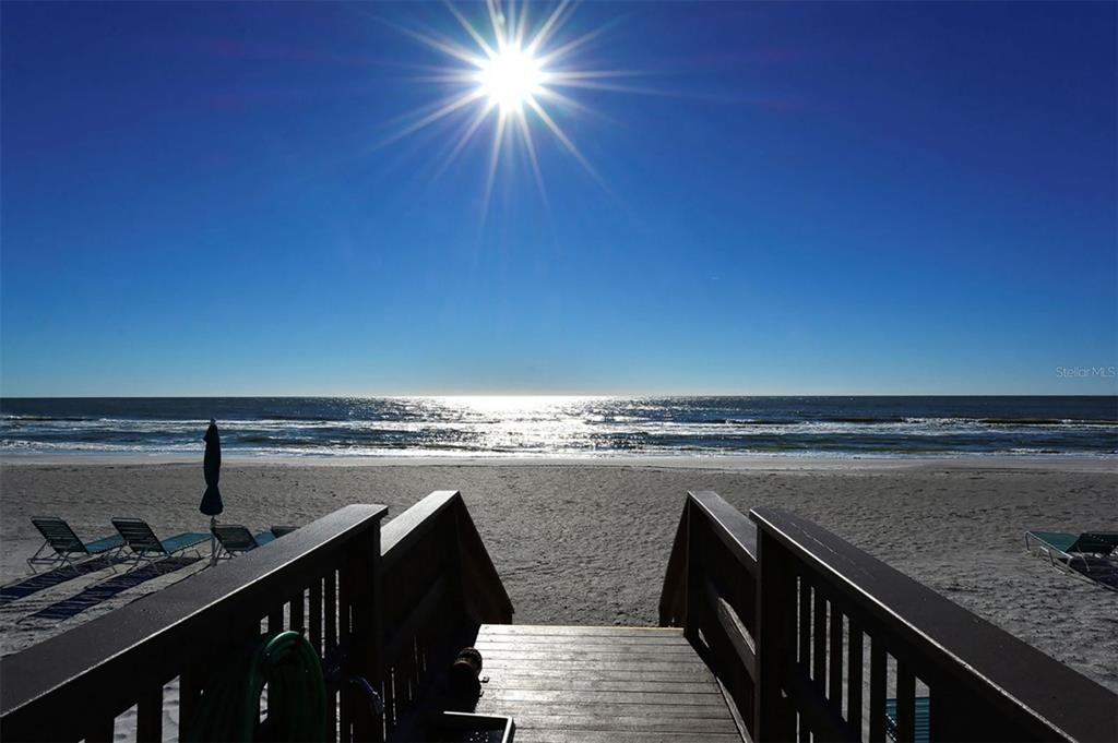 A balcony view overlooks a swimming pool, palm trees, and the ocean — 545 SANCTUARY DRIVE UNIT B305, LONGBOAT KEY, FL