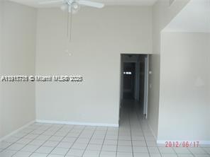 An empty room with white tiled floors, beige walls, and a ceiling fan — 1338 White Pine Dr, Wellington FL 33414, WELLINGTON, FL