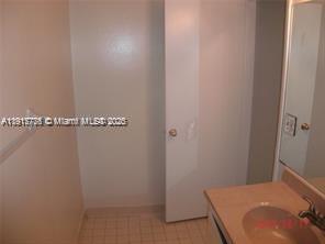 A bathroom features a vanity with a sink, a white door, and tiled flooring — 1338 White Pine Dr, Wellington FL 33414, WELLINGTON, FL