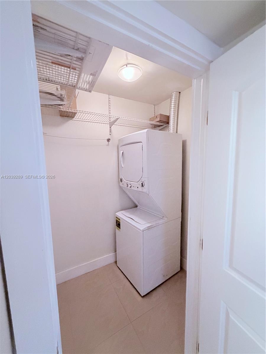 A laundry closet contains a stacked washer and dryer unit under wire shelving — 13872 SW 90th Ave, Miami FL 33176, MIAMI, FL