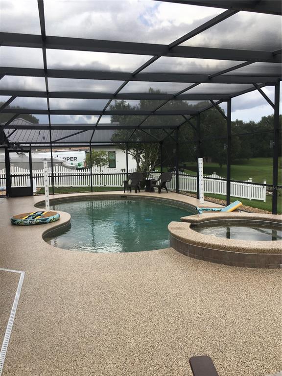 A single-story house with a brown roof, tan siding, and a large front lawn — 10502 LAKE HILL DRIVE, CLERMONT, FL