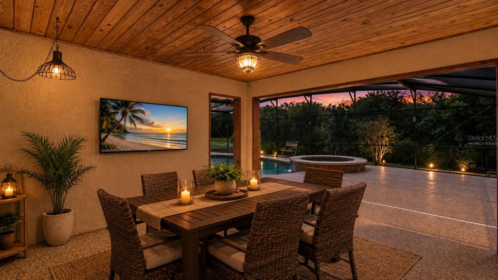 A covered outdoor dining area features a wooden ceiling, ceiling fan, and pool view — 10502 LAKE HILL DRIVE, CLERMONT, FL