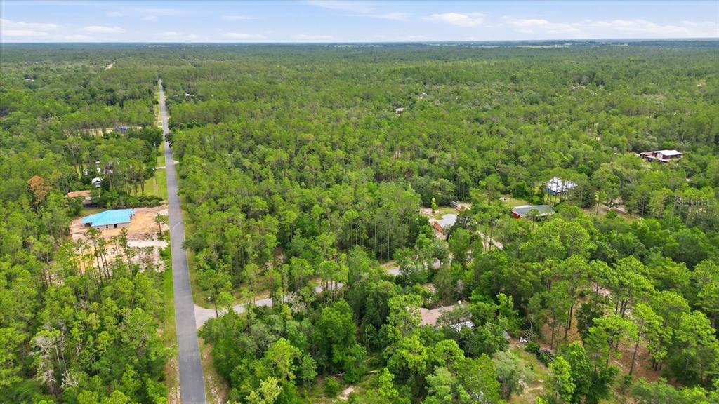 An aerial view shows a paved road running through a dense, wooded residential area — 0000 SW NAUTILUS BOULEVARD, DUNNELLON, FL