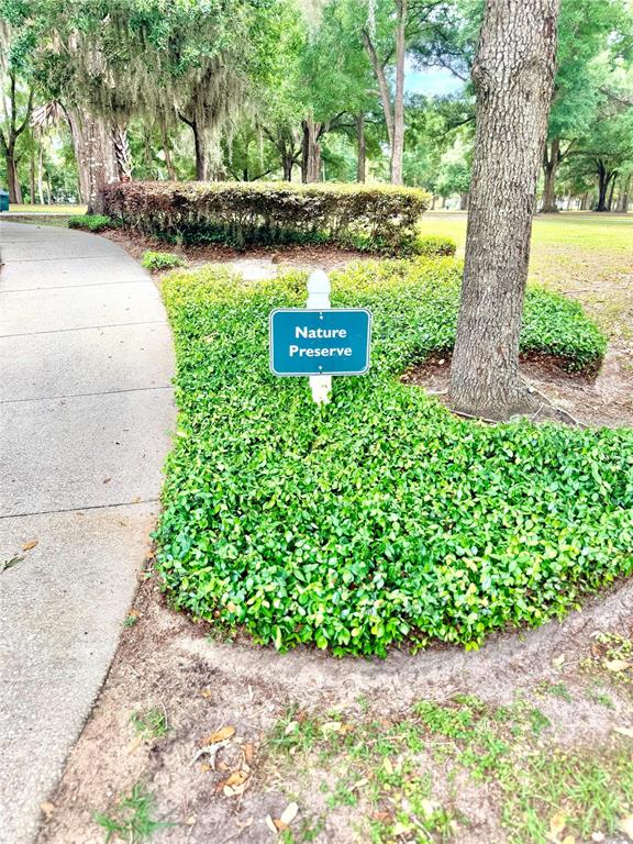 A sign reading Nature Preserve stands in a landscaped garden bed next to a sidewalk — 1541 HACKNEY TERRACE, DELAND, FL