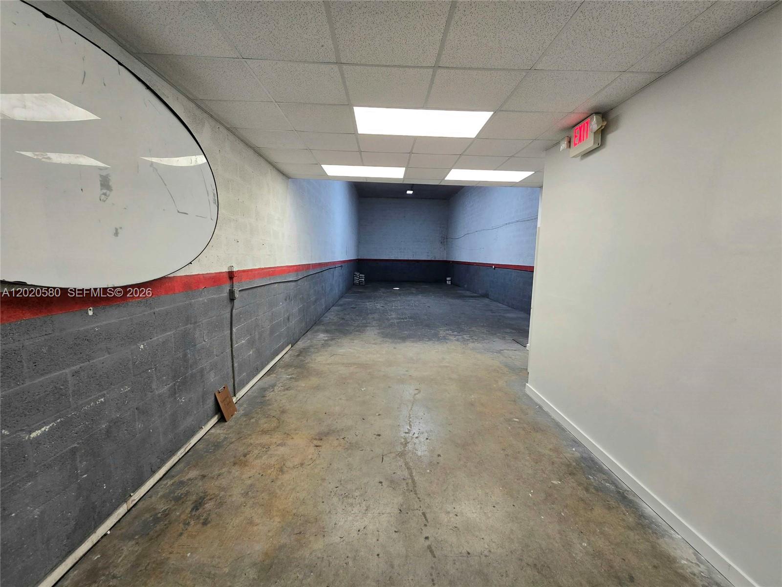 An empty industrial warehouse space features concrete walls with red trim and a drop ceiling — 7909 NW 64th St # 7909, Medley FL 33166, MEDLEY, FL