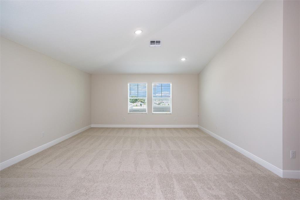 An empty room with beige carpet, light-colored walls, and two windows with white blinds — 31681 BIENVILLE LANE, WESLEY CHAPEL, FL