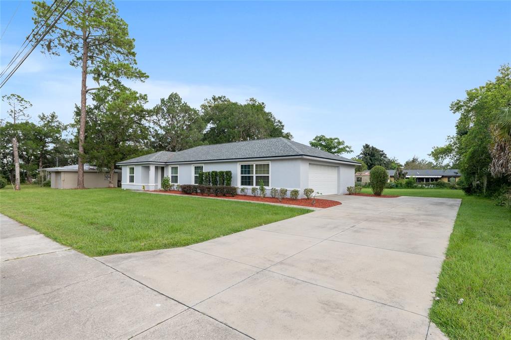 A single-story house with a gray exterior, a two-car garage, and a concrete driveway — 3424 NE 14TH STREET, OCALA, FL