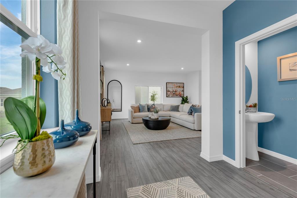 A view from a hallway into a living room with a powder room to the right — 856 CASTLEFORD AVENUE, PALM BAY, FL