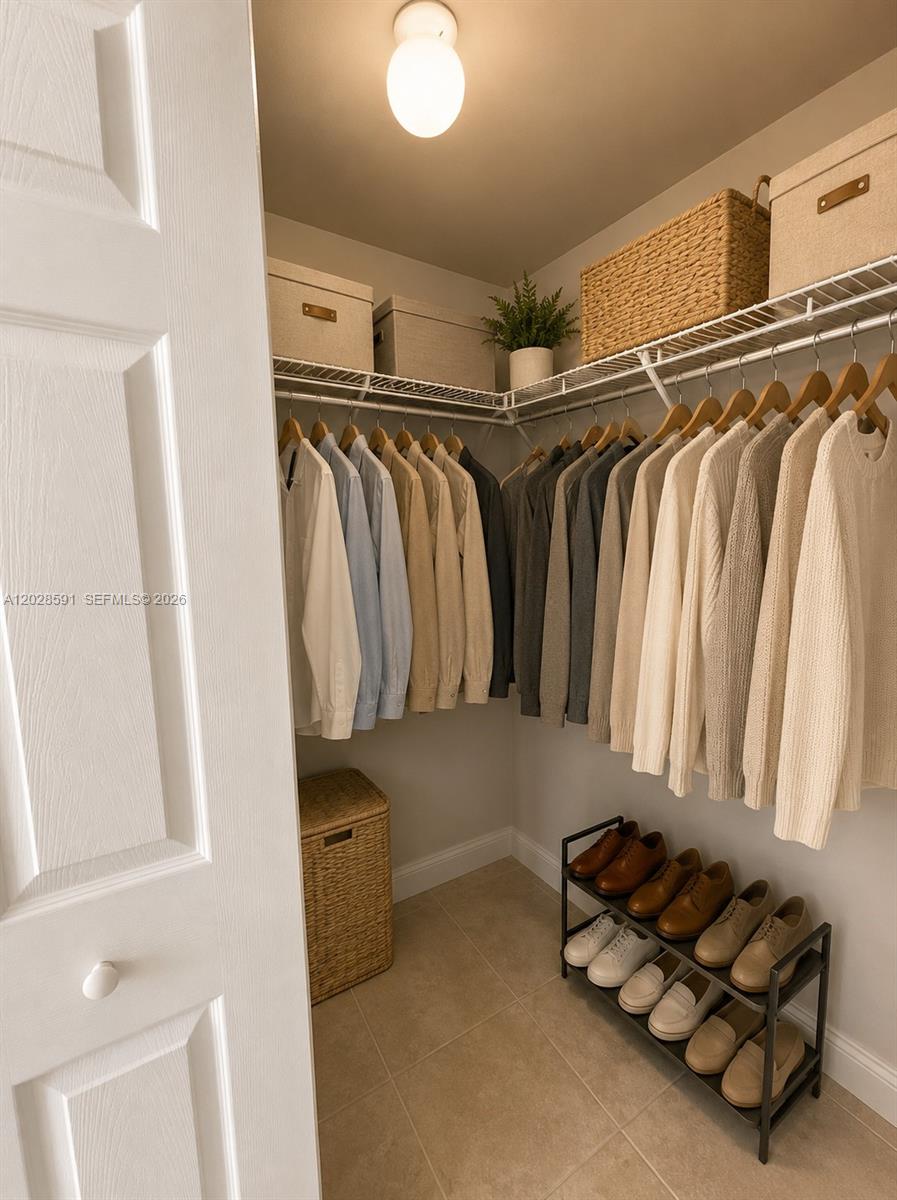 A walk-in closet features organized hanging clothes, storage bins on shelves, and a shoe rack — 140 S Dixie Hwy # 433, Hollywood FL 33020, HOLLYWOOD, FL
