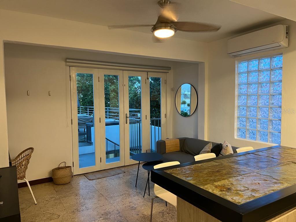 A living area features a stone-topped island, glass block window, and folding doors to a balcony — 50 Ismael Rivera Street OCEAN PARK UNIT 02, SAN JUAN, PR