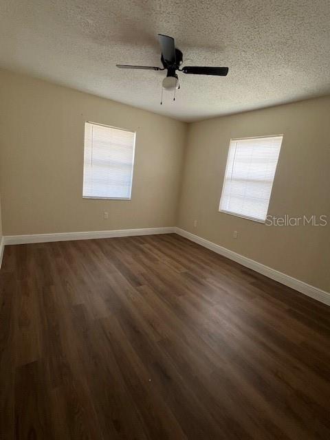 An empty bedroom features wood-look flooring, two windows with blinds, and a ceiling fan — 9004 TUDOR DRIVE UNIT K104, TAMPA, FL