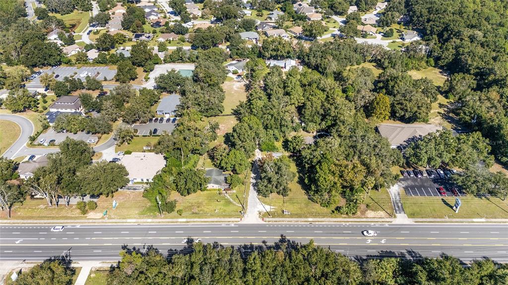 An aerial view shows a multi-lane road bordering a wooded lot with several buildings — 5985 W GULF TO LAKE HIGHWAY, CRYSTAL RIVER, FL