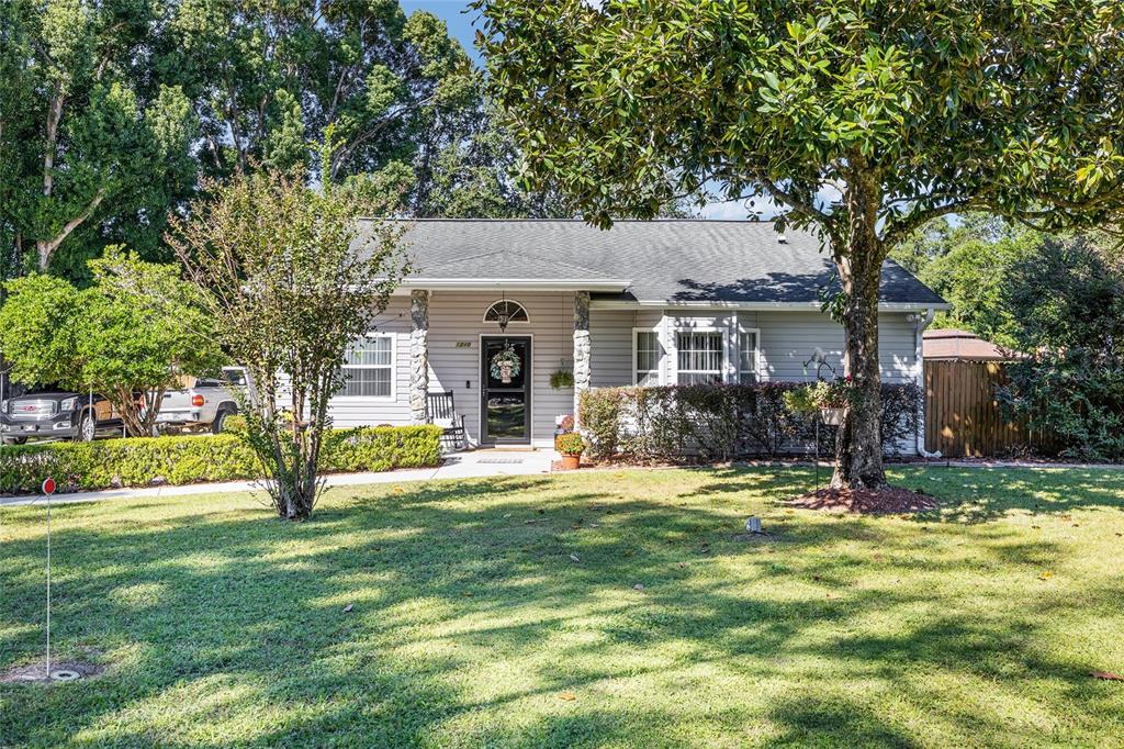 A single-story house with gray siding, a stone-accented porch, and a large front lawn — 5985 W GULF TO LAKE HIGHWAY, CRYSTAL RIVER, FL