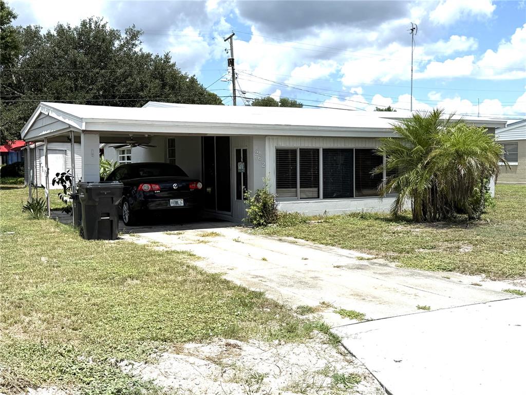 A single-story house with a white exterior, a carport, and a concrete driveway — 262 WALTER AVENUE, FROSTPROOF, FL