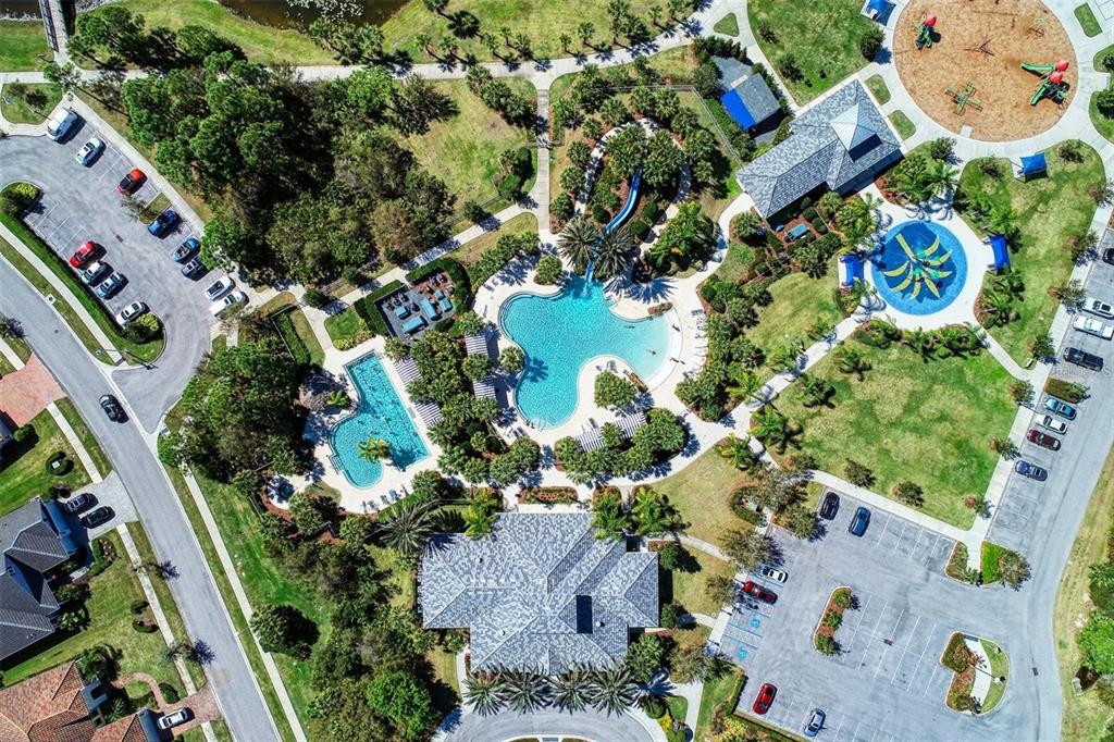 An aerial view shows a community pool complex with a waterslide, playground, and parking lots — 1358 STILL RIVER DRIVE, VENICE, FL