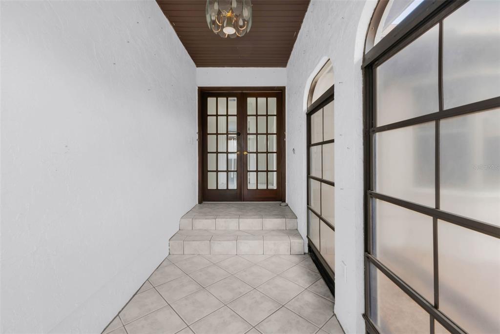 A tiled entryway features a dark wood double door, a ceiling light, and glass panels — 238 FRY TERRACE SE, PORT CHARLOTTE, FL