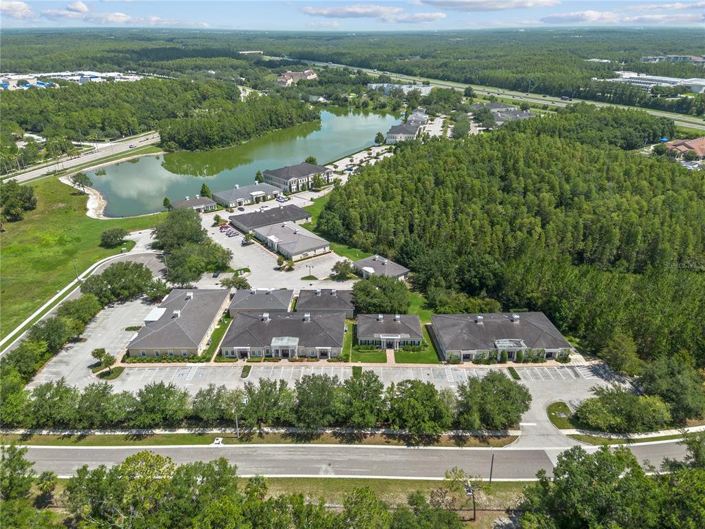 An aerial view shows a commercial office complex with multiple buildings, parking lots, and a lake — 5381 PRIMROSE LAKE CIRCLE, TAMPA, FL