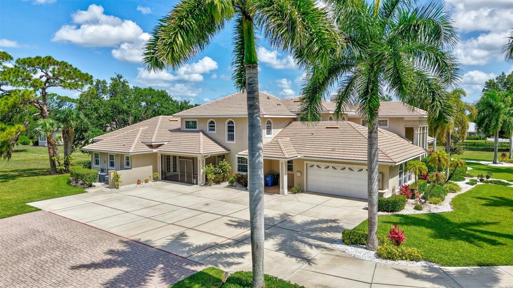 A paved driveway leads through a gated entrance toward a large two-story house — 1045 FOX CREEK DRIVE, SARASOTA, FL