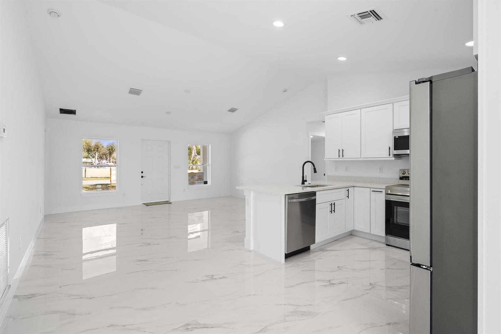 A white, single-story house with a dark roof and two dormers sits on a grassy lot — 17932 NW 288th Street, Okeechobee FL 34972, OKEECHOBEE, FL