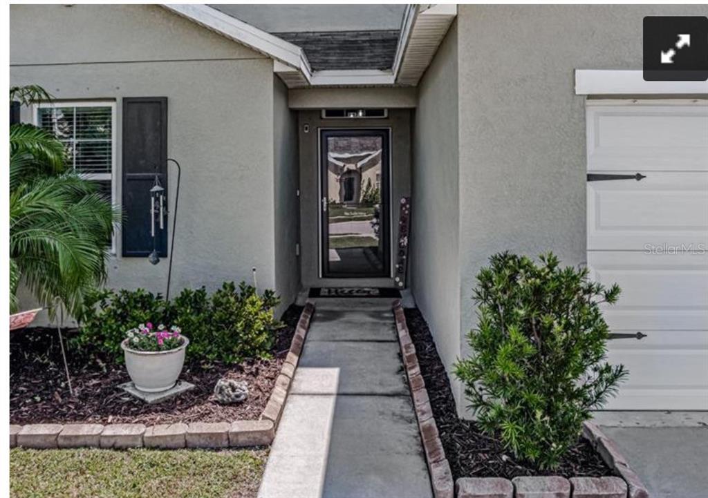 A concrete walkway leads to the front entrance of a house with a garage — 7114 58TH TERRACE E, PALMETTO, FL