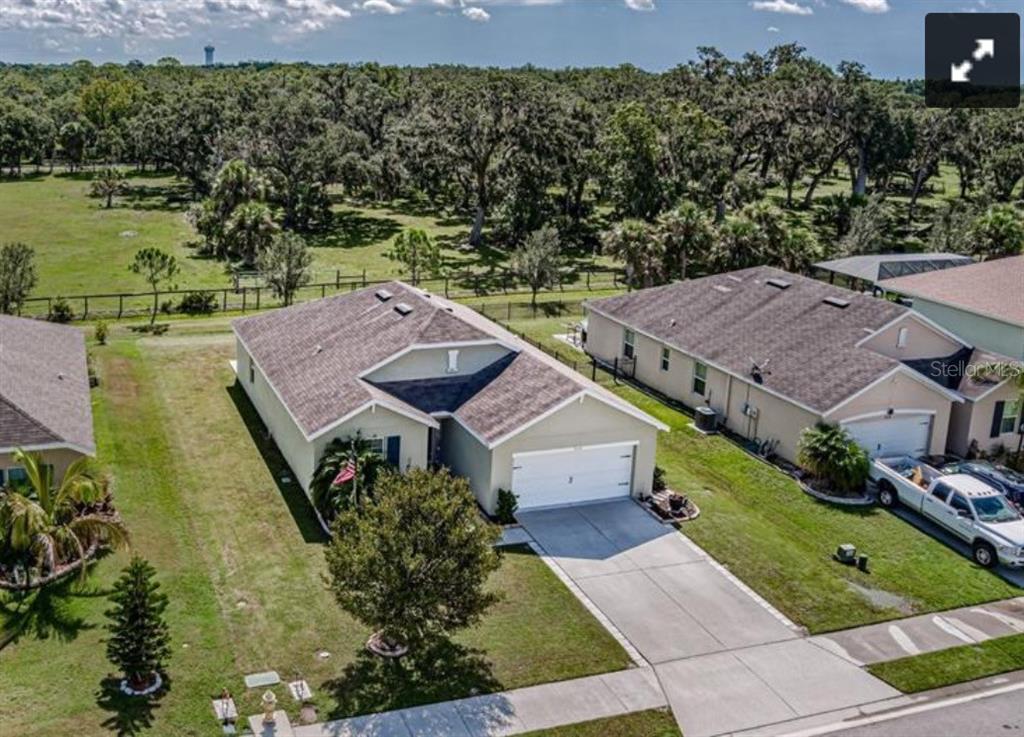 An aerial view of a suburban house with a two-car garage and a large backyard — 7114 58TH TERRACE E, PALMETTO, FL